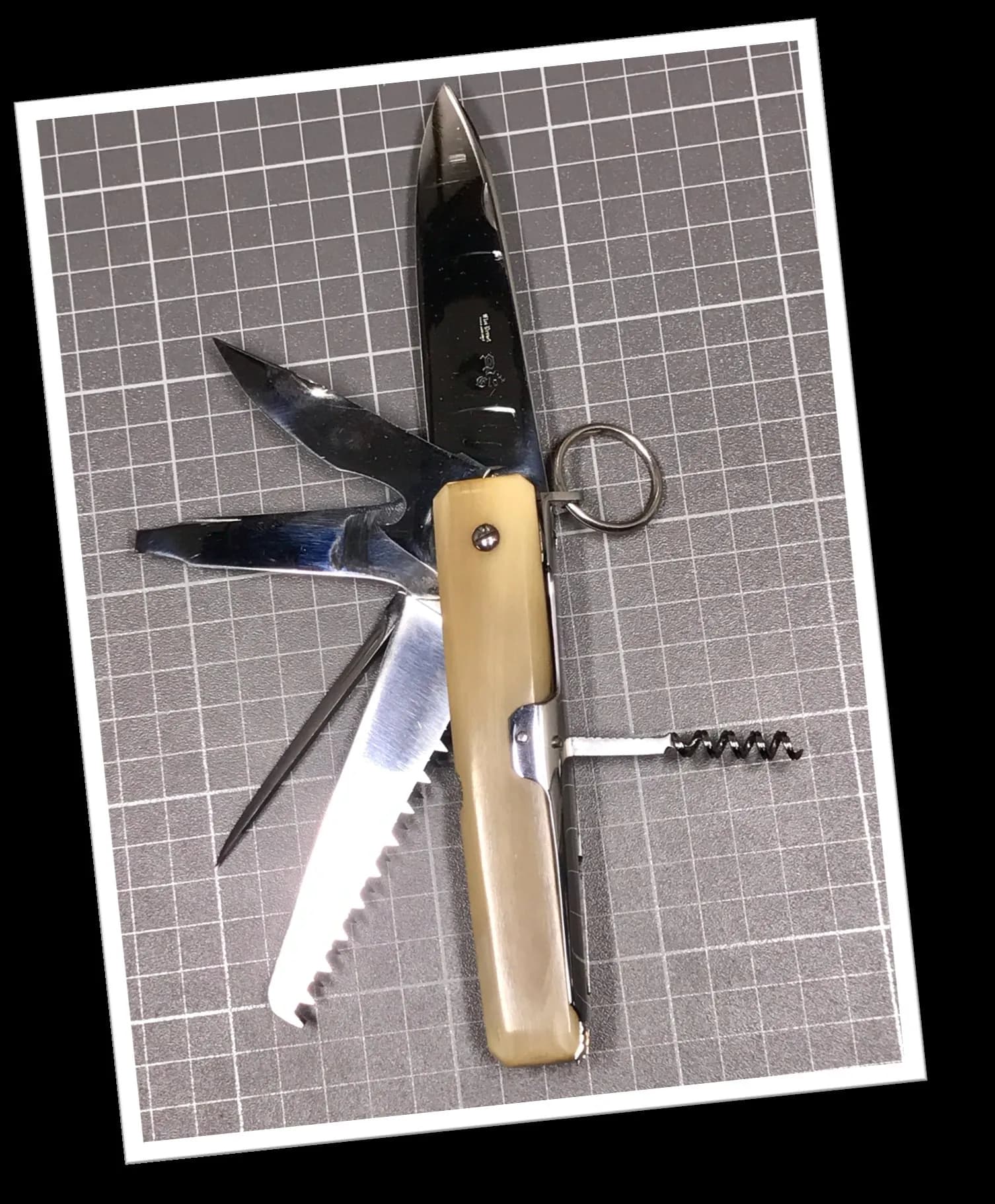 Couteau cran d'arrêt Eloi 1960 manche corne blonde octogonal, lames dépliées dont scie, corkscrew et poinçon visible